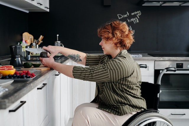 person in a wheelchair making themselves breakfast in their kitchen
